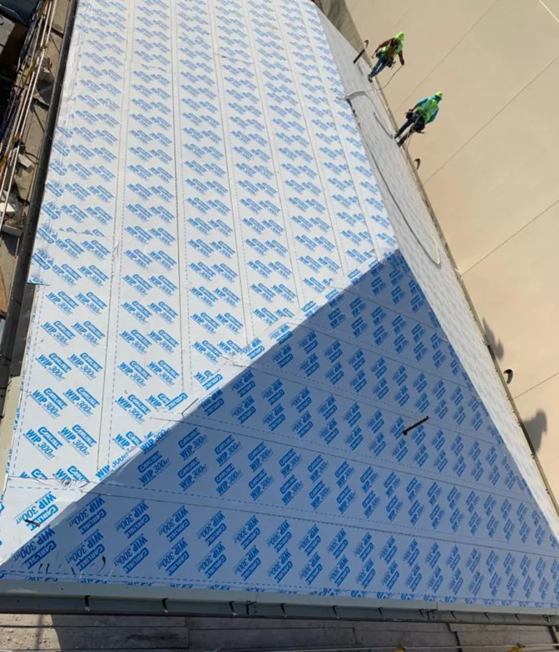 Professional roofers installing underlayment on a metal roof in New Philadelphia